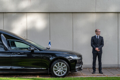 Volvo ja tyylikkäästi pukeutunut kuljettaja.
